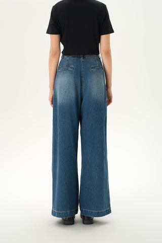 Woman wearing relaxed high-rise baggy jeans with soft pleats and cuffed hems