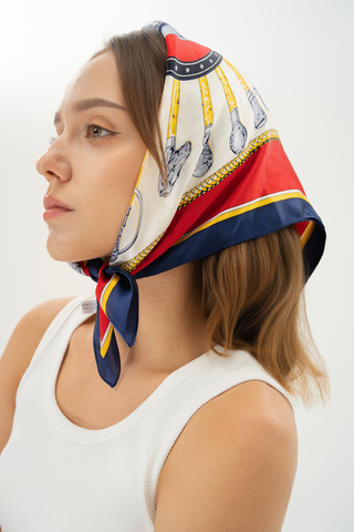 Woman wearing a navy, crimson, and gold silk scarf styled with vintage elegance 