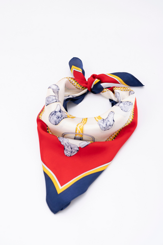 A navy, crimson, and gold silk scarf styled with vintage elegance 